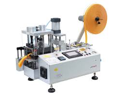 TW-150LR multifunctional computerized tape cutting machine with cold and hot cutting modes, digital control panel, precision feed rollers, and compact design, used for cutting various tapes in garment and manufacturing industries." TW-150LR multifunctional computerized tape cutting machine with cold and hot cutting modes, digital control panel, precision feed rollers, and compact design, used for cutting various tapes in garment and manufacturing industries."